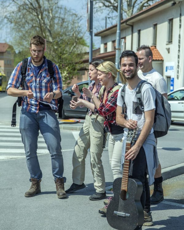 vertical-shot-young-happy-friends-singing-dancing-street_181624-27984